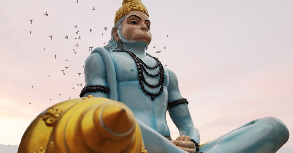 monkey-god hanuman archetype in blue in cross legged position with black beads around  neck and arm with gold weapon on a pink sky with birds background